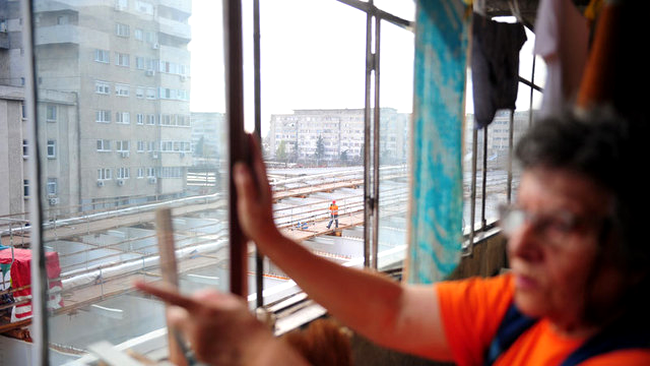 Locatarii din zona stau pe geam si se uita ca la cinema la muncitorii de pe Pasajul Basarab