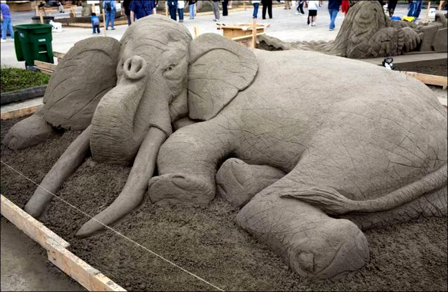 Un elefant din nisip este obosit si sta tolanit in... nisip