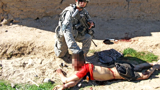 Soldat american pozandu-se cu tigara aprinsa, langa un civil afgan mort