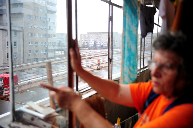 Locatarii din zona stau pe geam si se uita ca la cinema la muncitorii de pe Pasajul Basarab