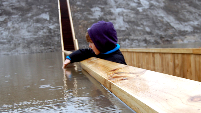 Un copil se joaca cu apa de pe Podul lui Moise