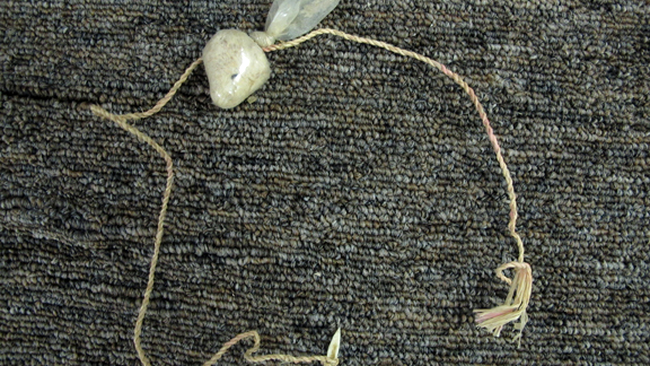 O bucată de sfoară, un cârlig din os și plut făcută din prezervativ - undița 