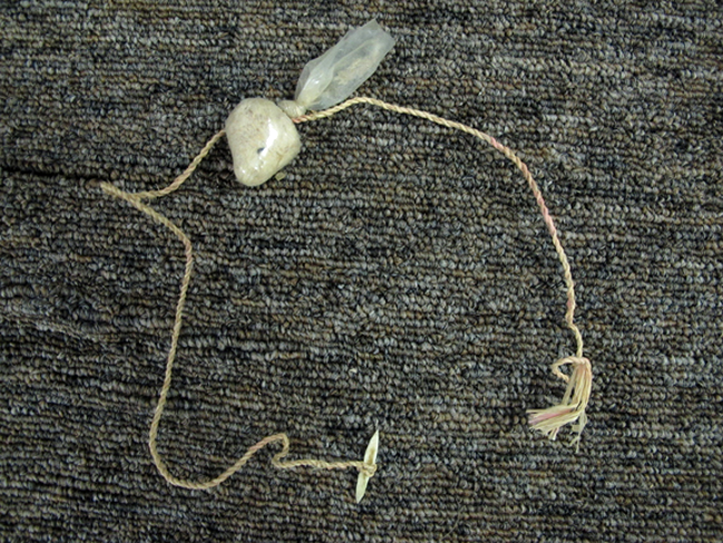 O bucată de sfoară, un cârlig din os și plut făcută din prezervativ - undița 