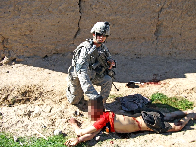 Soldat american pozandu-se cu tigara aprinsa, langa un civil afgan mort